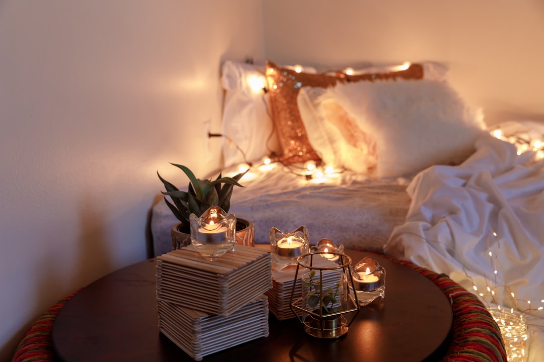 A calming setup with candles and a cozy bed, suggesting a relaxing atmosphere.